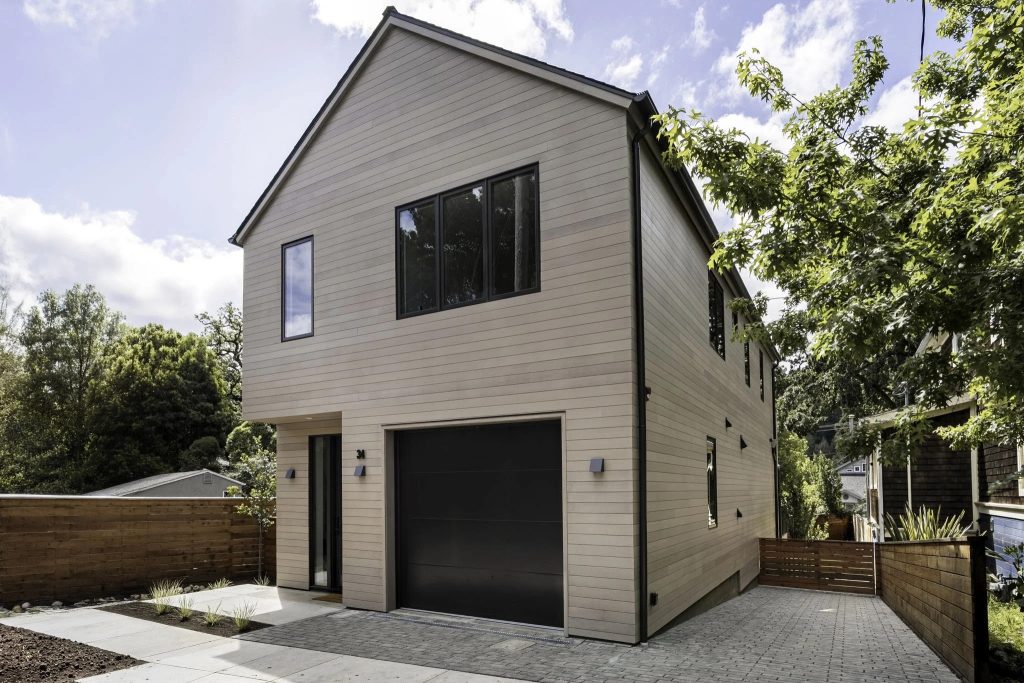 Two-story modern home with horizontal ACRE siding in a warm taupe finish and black-framed windows.
