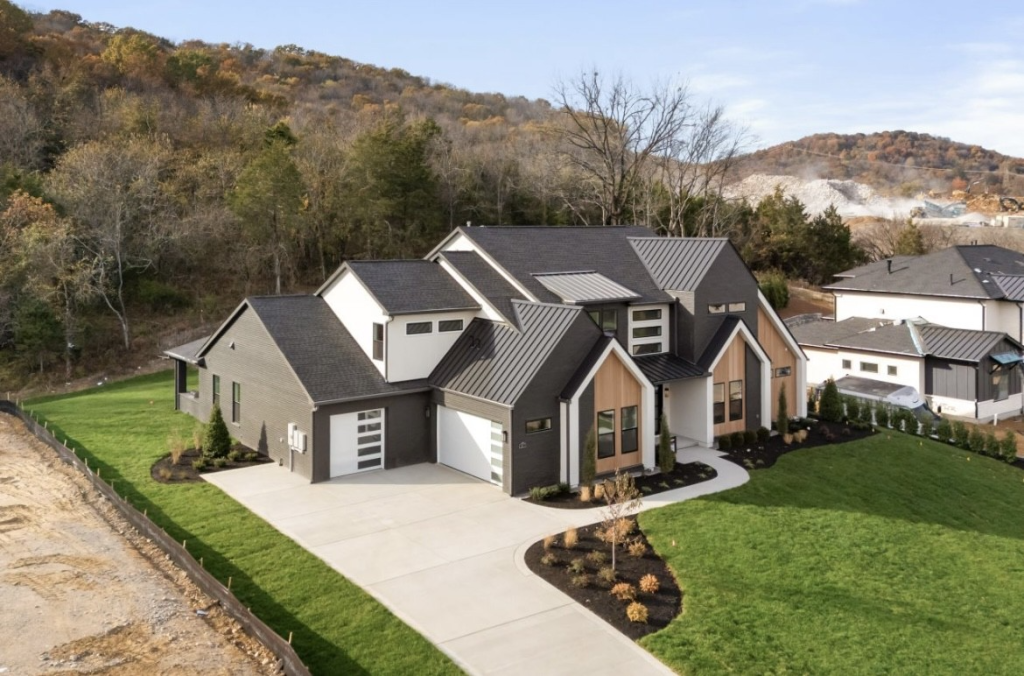 ACRE siding on a modern farmhouse exterior featuring board and batten and horizontal lap siding in dark and light tones with a metal roof and manicured lawn