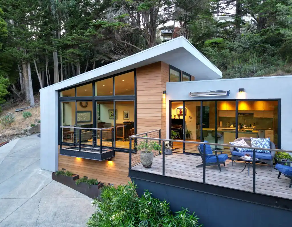 ACRE horizontal lap siding on a contemporary home with a shed roof, large floor-to-ceiling windows, and an outdoor deck with cable railing at dusk