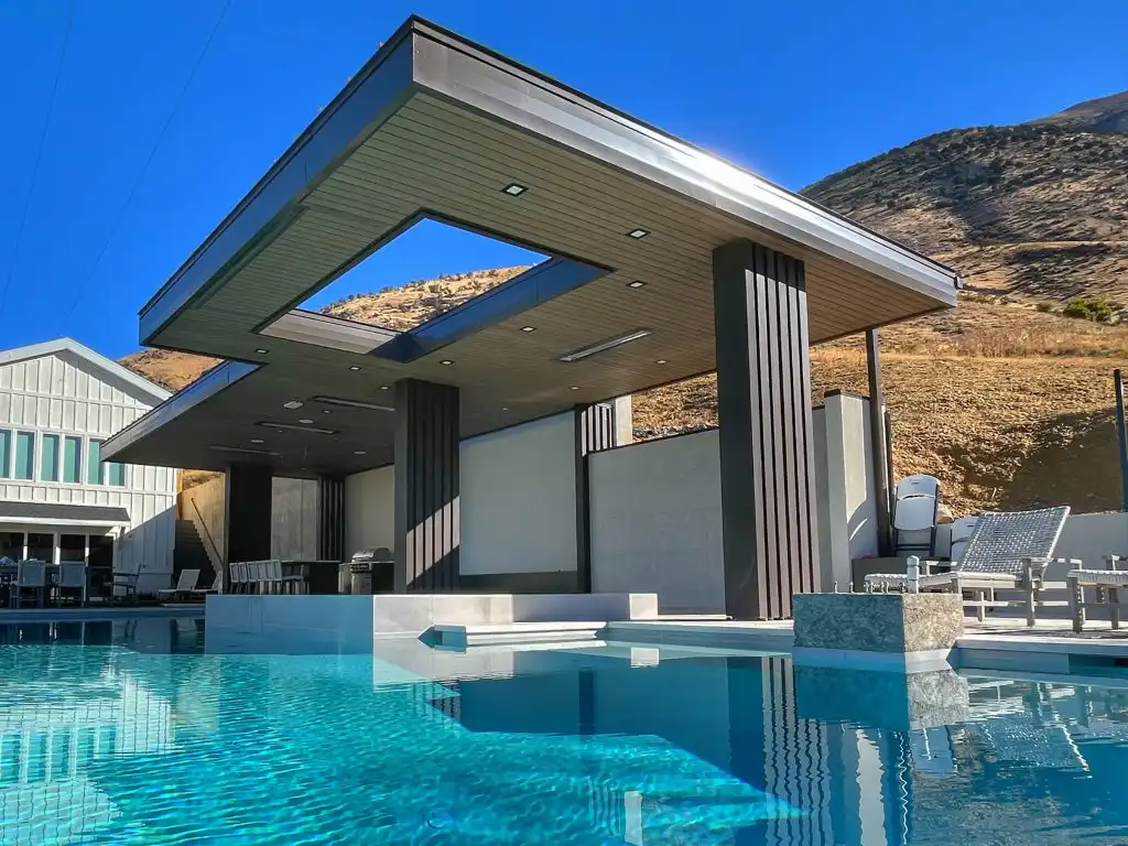 Pool pavilion in Cedar Hills, Utah with dark composite ceiling panels and vertical composite siding columns beside an infinity pool