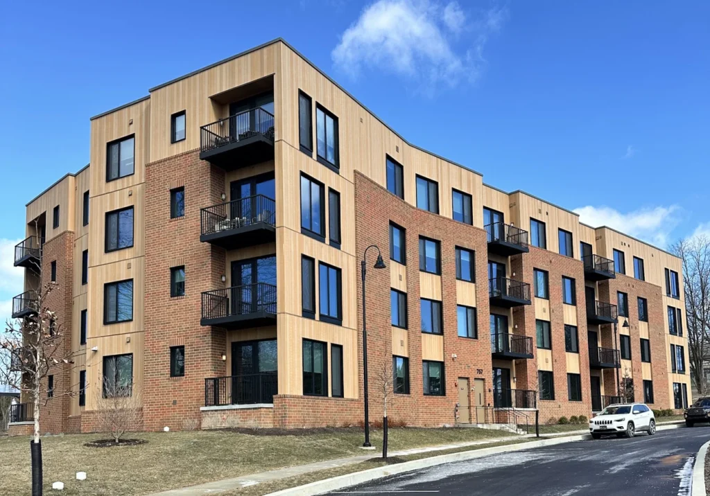 ACRE composite siding paired with brick on a four-story apartment building