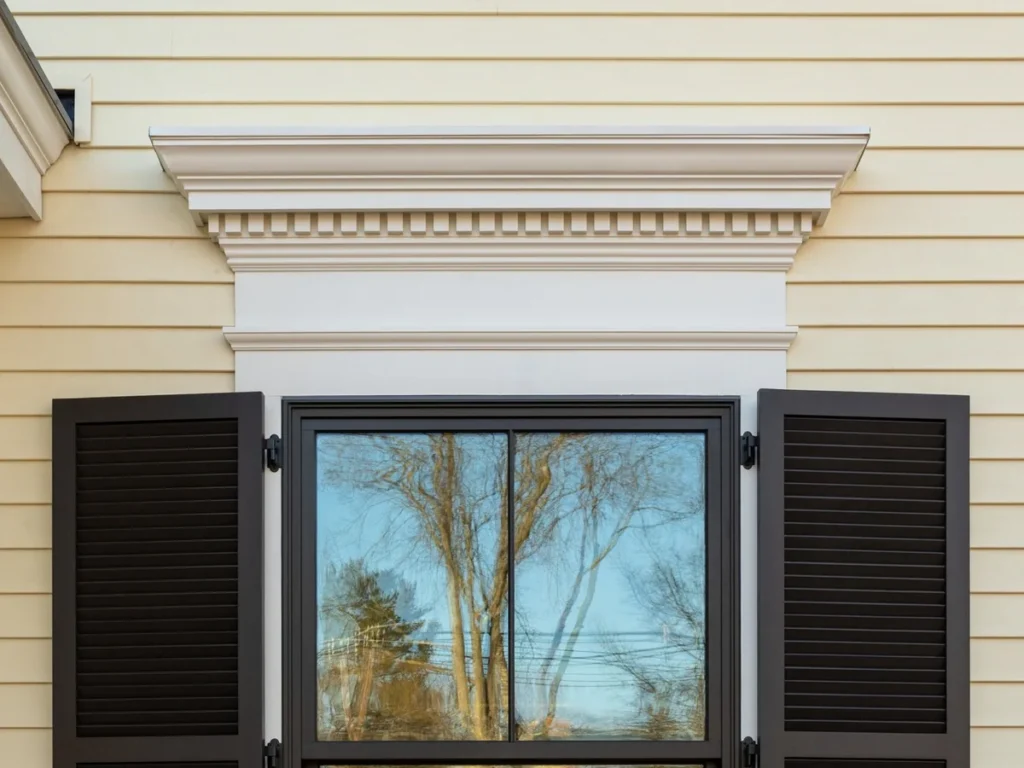 Painted ACRE composite trim forming a decorative window header and casing