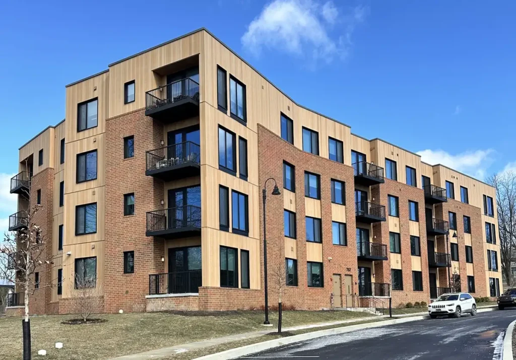ACRE composite siding paired with brick on a four-story apartment building